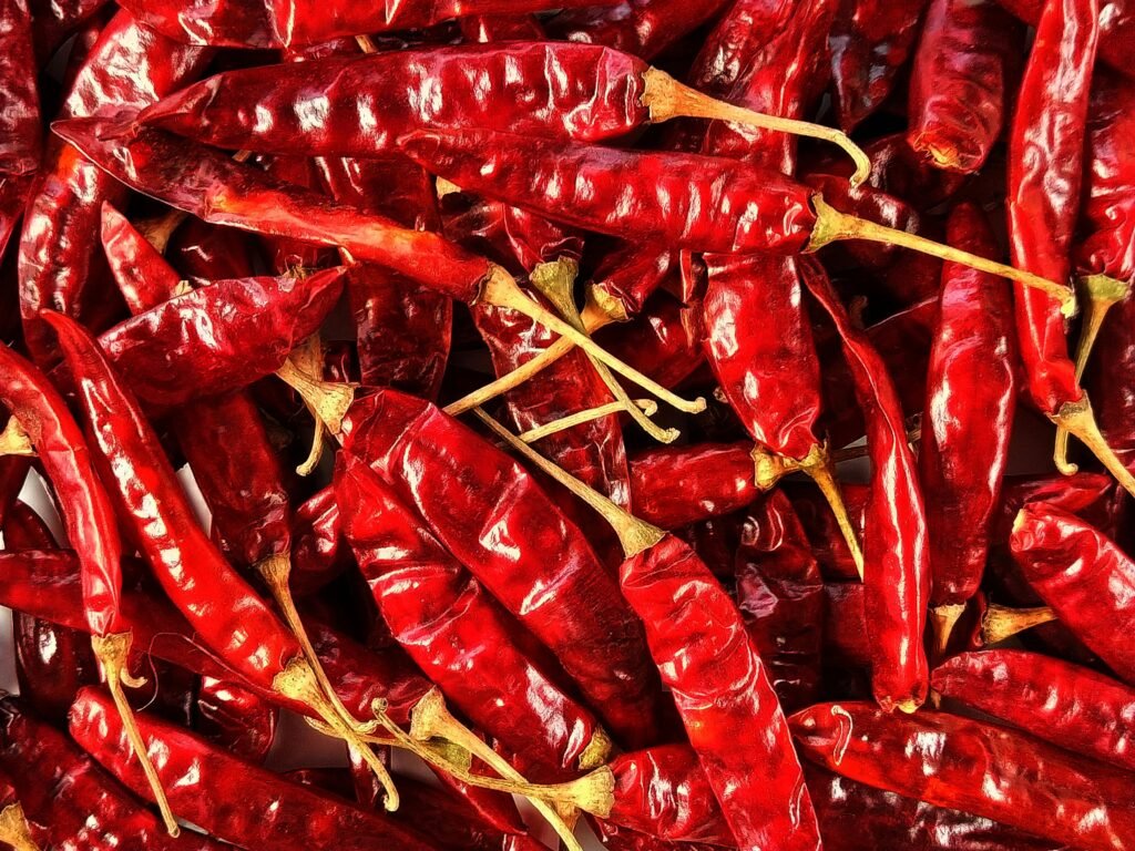 High-resolution image of dried red chili peppers in a pile, showcasing texture and detail.