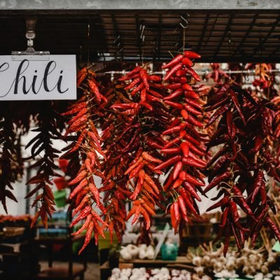 A colorful display of red dried chili peppers hanging at a market stall in Montreal.