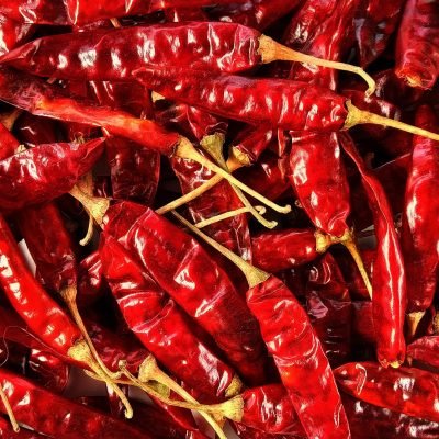 High-resolution image of dried red chili peppers in a pile, showcasing texture and detail.