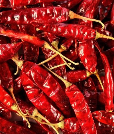 High-resolution image of dried red chili peppers in a pile, showcasing texture and detail.